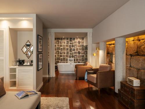 a living room with a bath tub and a living room with a couch at Pestana Vintage Porto Hotel & World Heritage Site in Porto
