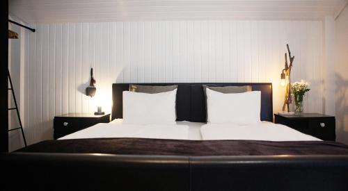 a bed with two white pillows and two night stands at Ferienhaus Kollinger in Kaprun