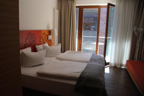 a hotel room with a bed and a balcony at Hotel Begardenhof in Cologne