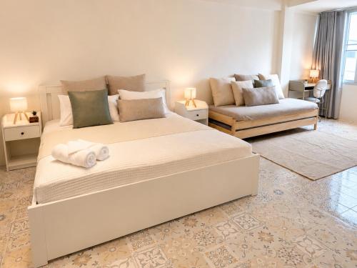 a bedroom with a large white bed and a couch at 95 Lodge in Bangkok
