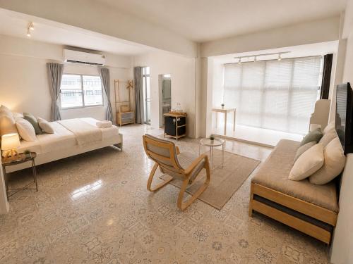 a living room with a bed and a couch and a chair at 95 Lodge in Bangkok