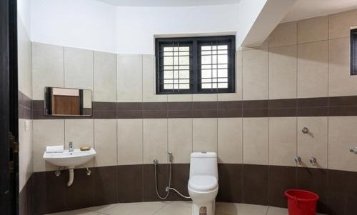 a bathroom with a toilet and a sink at Vayal Heritage Villa in Angamaly