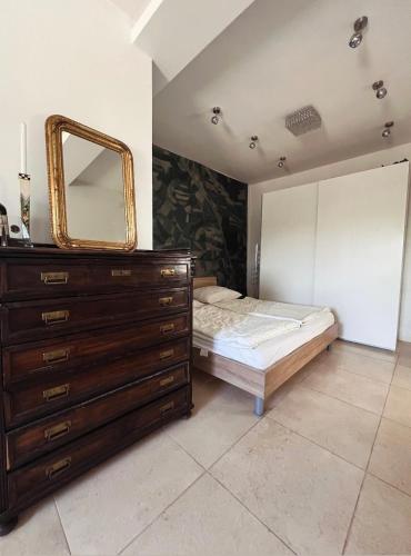 a bedroom with a bed and a dresser with a mirror at Landidyll am Bauerhof in Sankt Valentin