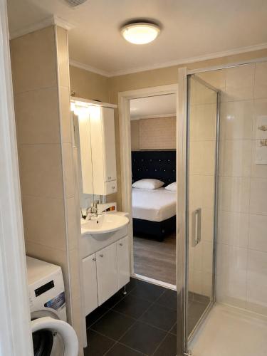 a bathroom with a shower and a sink and a bed at BLUE BEACH HOUSE in Breskens
