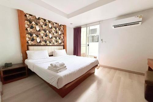 a bedroom with a bed with towels on it at Eurna Resort Hotel in Bangkok