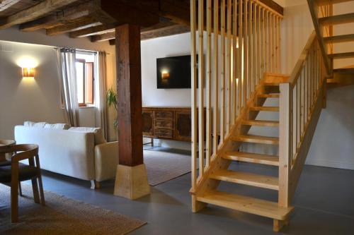 a wooden staircase in a living room with a couch at AIXPE apartamentos boutique in Osma