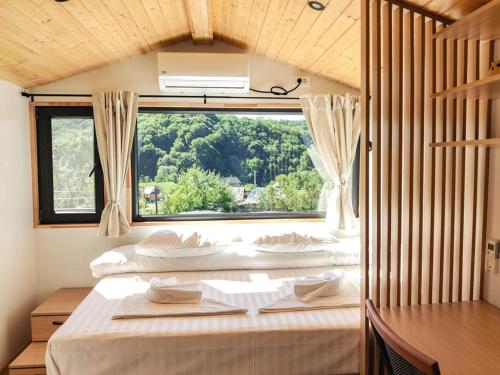 a bedroom with two beds and a large window at InPlai Cabins in Albestii de Arges