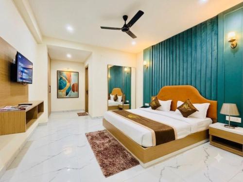 a bedroom with a large bed and a television in it at Hotel De - Grand Villa Near Delhi IGI Airport in New Delhi
