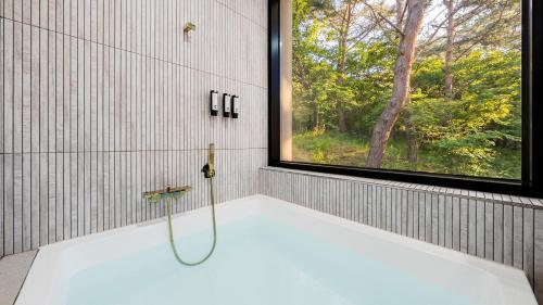 a bath tub with a shower and a window at Wonju Healing Forest in Wonju