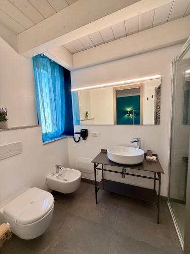 a bathroom with two sinks and a toilet at SiRiuS rooms & charme in Villasimius
