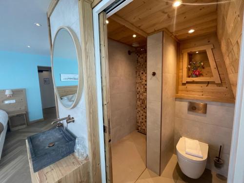 a bathroom with a shower and a toilet in a room at Hôtel Restaurant Saint Roch in Puy-Saint-Vincent