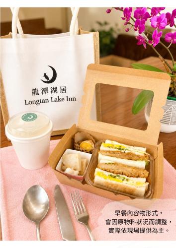 a lunch box with a sandwich and a tote bag at Longtan Lake Inn in Jiaoxi