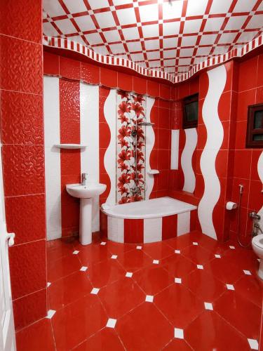 a red and white bathroom with a tub and a sink at شقة مميزة بجوار كورنيش النيل اسوان - عائلات فقط in Aswan