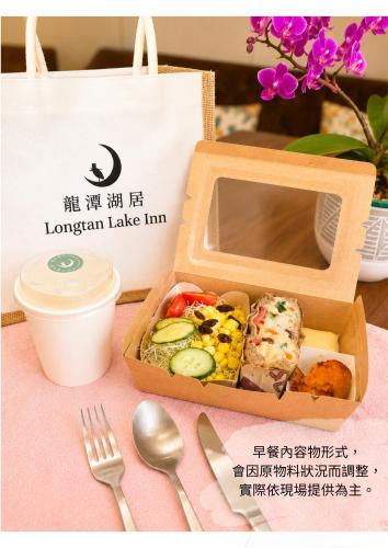 a lunch box with food in it on a table at Longtan Lake Inn in Jiaoxi