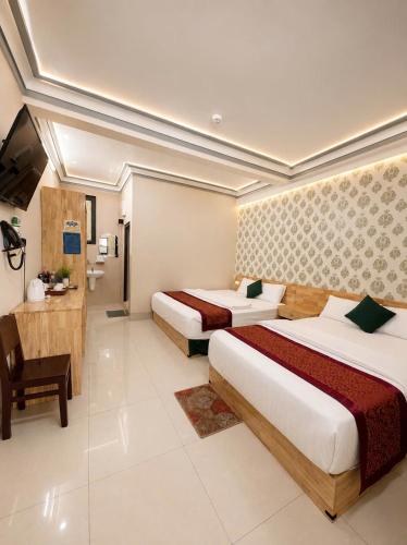 a hotel room with two beds and a television at Khách Sạn The Second in Thốt Nốt