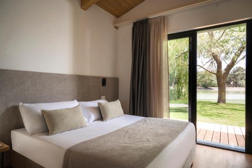 a bedroom with a bed and a large window at The Village Chalet in Castel di Sangro