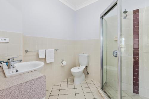 a bathroom with a toilet and a sink and a shower at La Vida on Anzac in Redcliffe