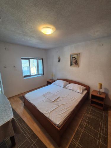 a bedroom with a large bed with white sheets at Lila apartments in Bijakovići