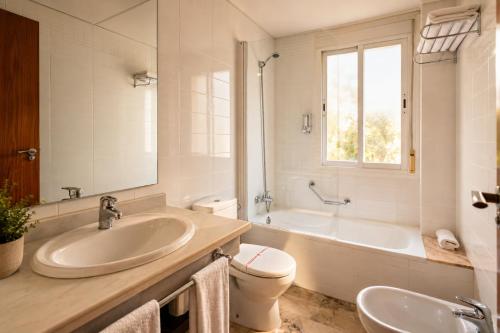 a bathroom with a sink and a tub and a toilet at Apartamentos Vértice Bib Rambla in Seville