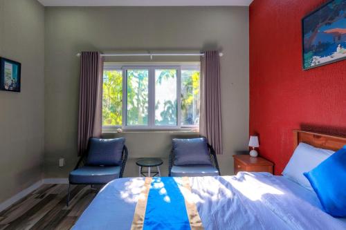 a bedroom with two chairs and a bed and a window at Private Ocean-View Pool Villa, Phan Thiet Beach in Tiến Thành
