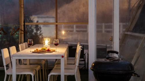 a table with two glasses of wine and a grill at Sokcho Night Sky Pension in Sokcho