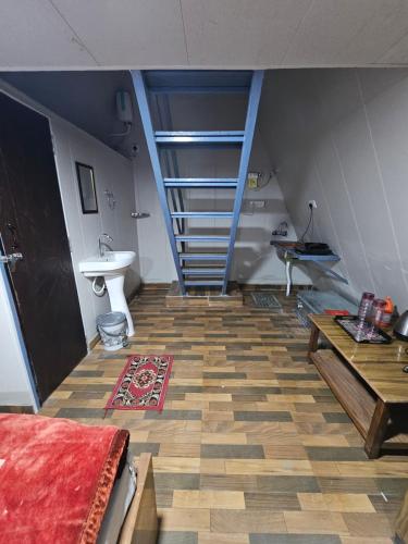 a room with a staircase and a floor with a rug at Monal Nests in Champawat