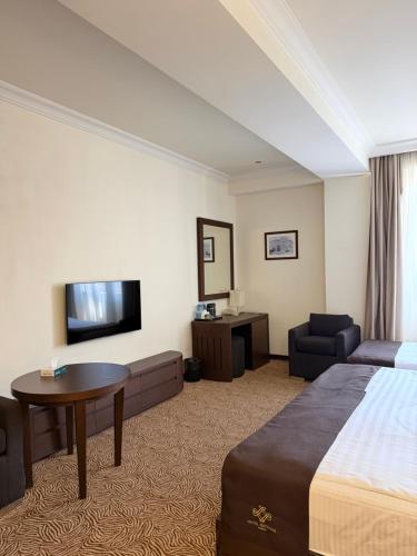 a hotel room with a bed and a tv at National by Stellar Hotels, Yerevan in Yerevan