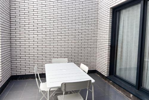 a white table and chairs next to a brick wall at InsideHome Ciudad de Valladolid in Valladolid