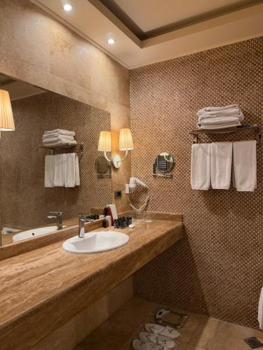 a bathroom with a sink and a mirror and towels at National by Stellar Hotels, Yerevan in Yerevan