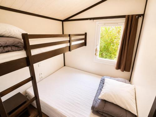 a small bedroom with a bunk bed and a window at Chalet Riviera in Autruy-sur-Juine