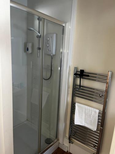 a shower stall in a bathroom with a towel at Mews Apartments in Lincoln