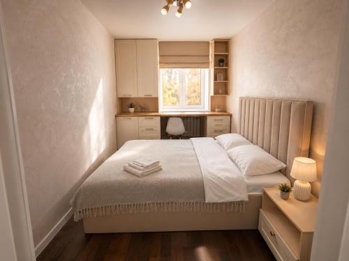 a small bedroom with a bed and a kitchen at Люкс в центре Караганды in Karagandy