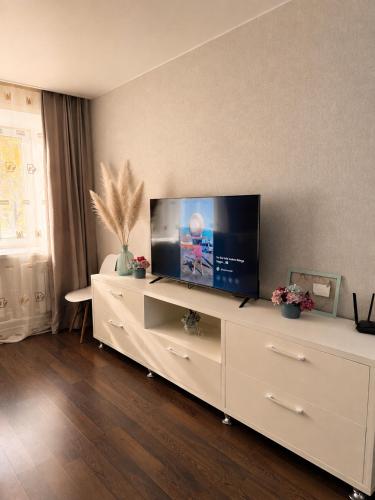 a living room with a large white entertainment center with a flat screen tv at Люкс в центре Караганды in Karagandy