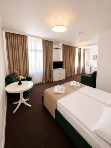 a hotel room with two beds and a table at HOTEL OPAL Zalau in Zalău