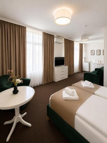 a hotel room with a large bed and a table at HOTEL OPAL Zalau in Zalău