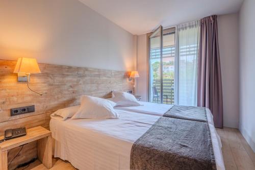 a bedroom with a large bed and a window at Arrels d'Emporda in Palafrugell