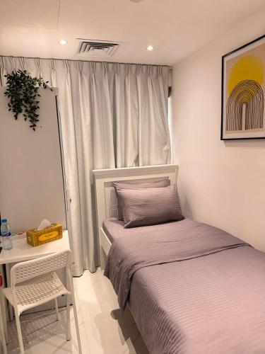 a bedroom with two beds and a table and a window at Vogue Inn in Abu Dhabi