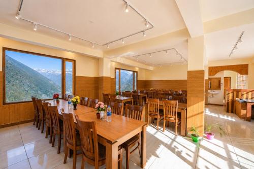 a large dining room with a table and chairs at Hotel Biker Gang Hotel & Cafe in Kyelang