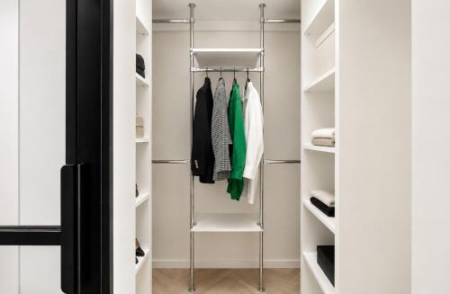 a walk in closet with white walls and white shelves at Pastel Apartment - Ergo Arena in Gdańsk