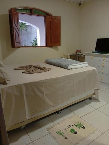 a bed sitting in a room with a window at Casa do Mandacaru in Bom Jesus da Lapa