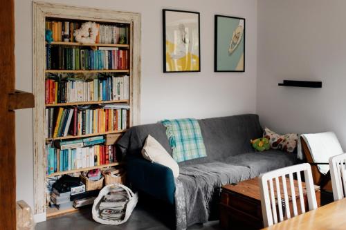 a living room with a couch and book shelves filled with books at Leśniczówka Dobrocin in Małdyty
