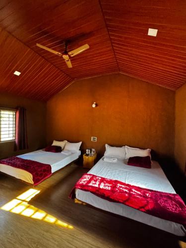 a bedroom with two beds in a room at Marayoor Mud Castle in Maraiyūr
