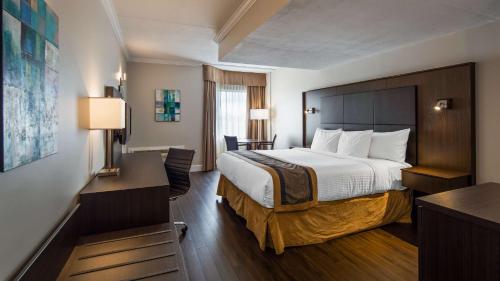 a hotel room with a bed and a desk at Best Western Laval-Montreal in Laval