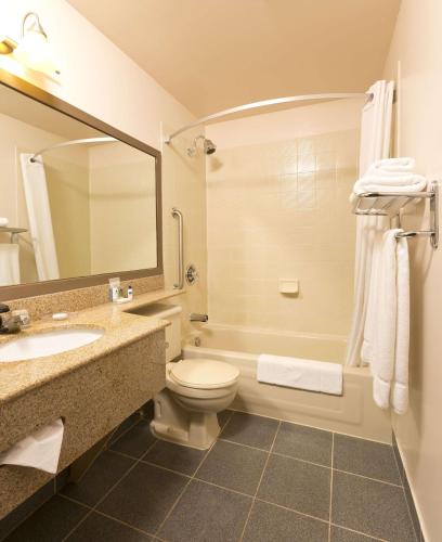 a bathroom with a toilet and a sink and a mirror at Best Western Laval-Montreal in Laval