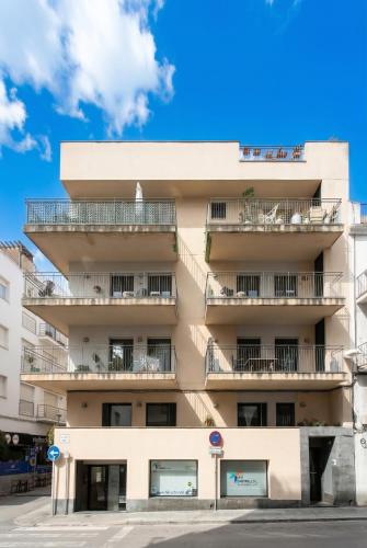 an apartment building with balconies and a blue sky at INASS in Sitges