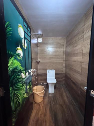a bathroom with a toilet and a plant on the wall at Marayoor Mud Castle in Maraiyūr