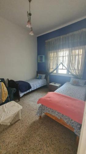 a bedroom with two beds and a window at Furnished accommodation S2 in Nabeul in Nabeul