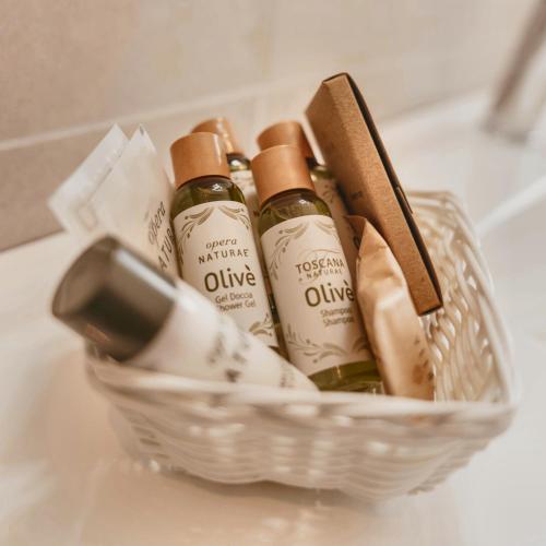 a basket filled with bottles of wine on a sink at My Tuscany Pink Suite in San Quirico dʼOrcia