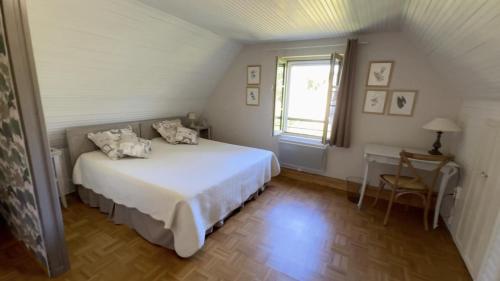 a bedroom with a white bed and a window at Côté gartempe in Les Hermitières