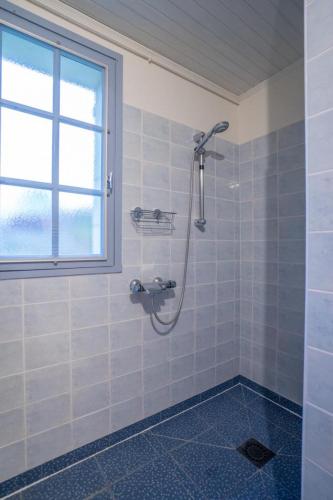 a shower in a tiled bathroom with a window at Côté gartempe in Les Hermitières